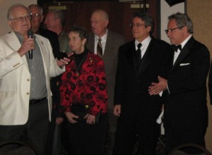 1954 Milan team member Bobby Plump prepares to present commemorative rings to Pizzo and Anspaugh at the induction banquet. Third from left is Steve Hollar.